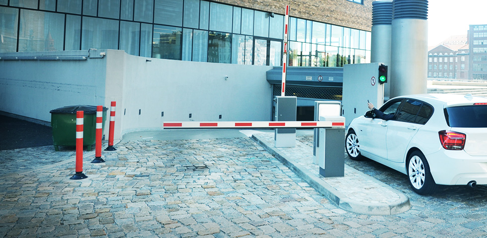 Car stands in front of a gate that is being opened via  parku's sesam device